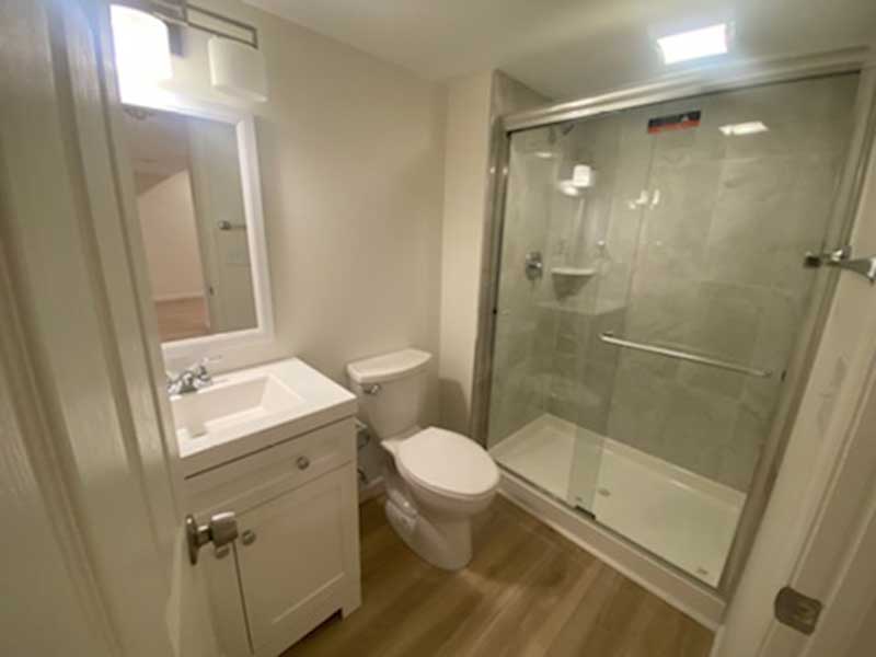 The Basic Bathroom Co. - full bathroom installation including a sink, vanity, faucet, toilet, shower pan and plumbing, and shower trim for a full bathroom build in a finished basement in Southampton, Pennsylvania – December 2022